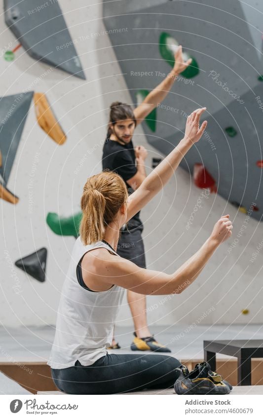 Sportspeople practicing grabbing technique near climbing wall sportspeople training alpinism healthy lifestyle exercise practice explain alpinist learn hobby