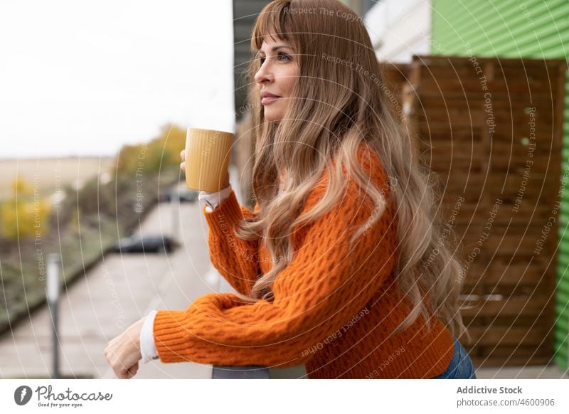 Woman drinking beverage on balcony woman hot drink terrace pastime refreshment feminine dreamy female leisure lady light mug cup coffee charming long hair enjoy