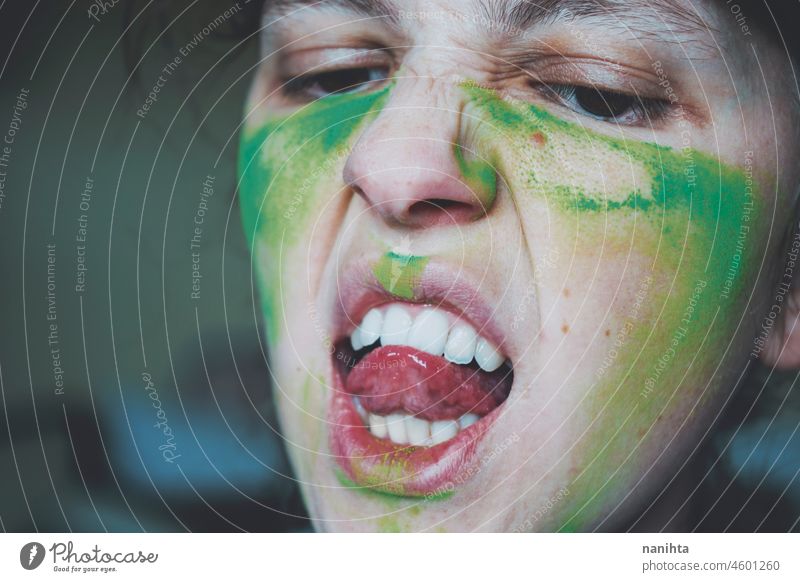 Angry young woman with her face painted with green dust rage anger warrior teeth real painting skin close close up emotion emotional emotive mood intense