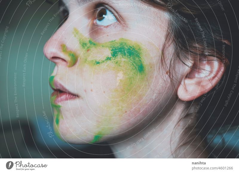 Moody portrait of a young woman with her face painted of green depression depressed hopeless emotional emotive mood intense psychology human human being natural