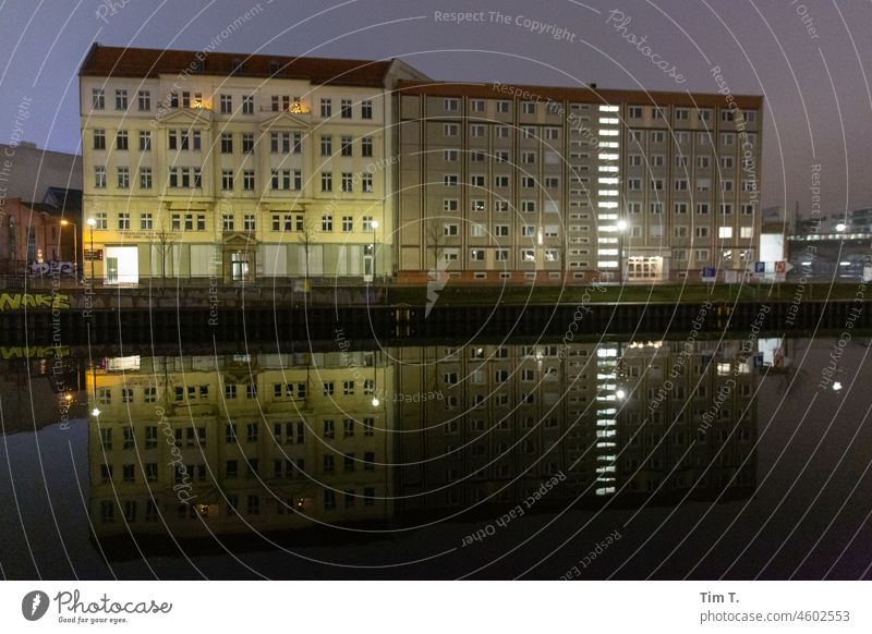 an old building and a prefabricated building look next to each other at the Spree Berlin Middle Night river Prefab construction Old building Town Capital city