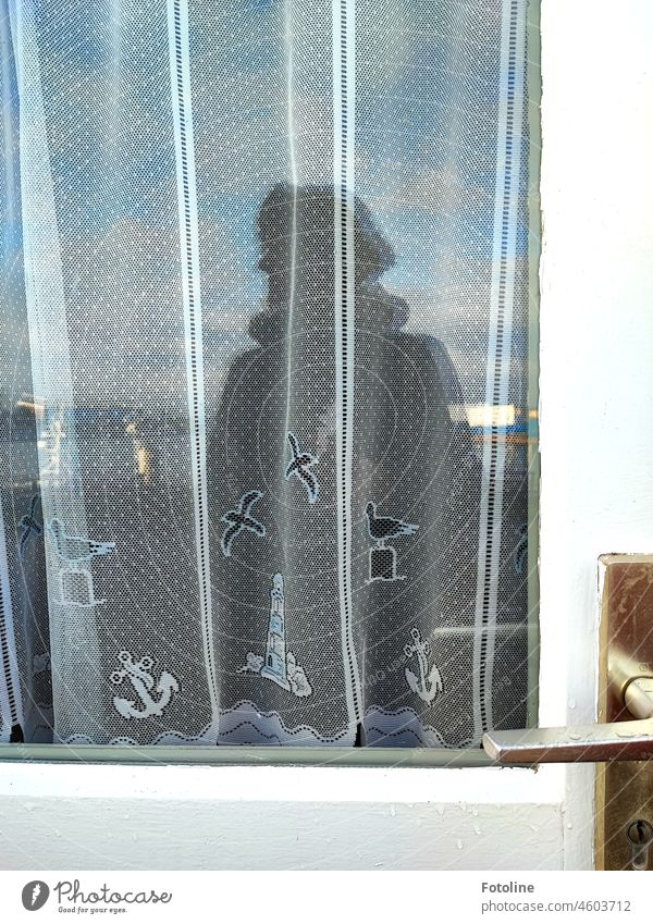 She stands in front of a door with maritime motifs and considers...to the right to the ferry or to the left back to the dune Helgoland. door handle Window