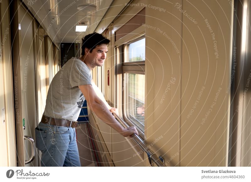 Solo travel A middle-aged man travels alone by train. He stands in an empty train car and looks out the window New normal male traveling texting journey