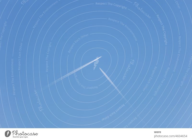 Two airplanes flying towards each other at right angles in a blue sky Augsburg Contrails Germany Hoarfrost covered Siebenbrunn cold copy space forest landscape