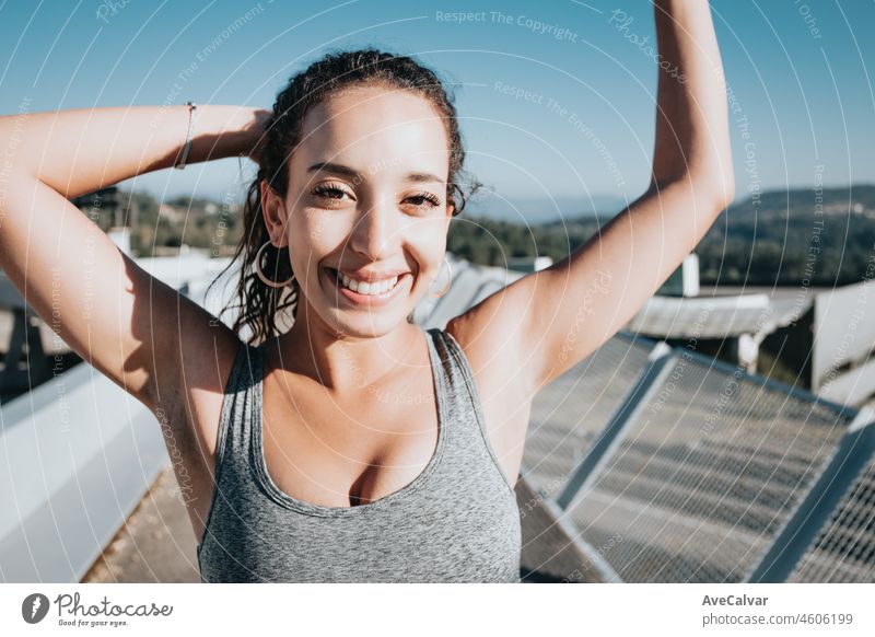 Close portrait of a smiling young african arab poc happy after finishing her training. New habits fit life new year concept. Colorful, losing weight gaining health concept