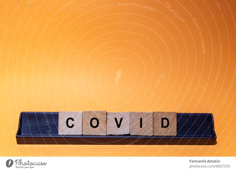 Coronavirus. Covid-19 written with letters. Orange background and space for text. Horizontal photography. coronavirus illness epidemic pandemic medical vaccine