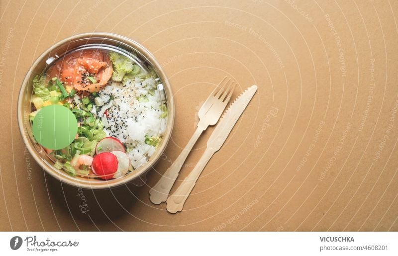 Healthy salad lunch with salmon in craft-paper recycled bowl packages with wooden cutlery. Top view. Sustainable food delivery. Reduce plastic. Environment and  eco-friendly lifestyle