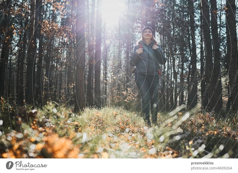 Woman enjoying hike on sunny vacation day. Female with backpack walking through forest path trip hiking adventure travel summer journey wanderlust hiker