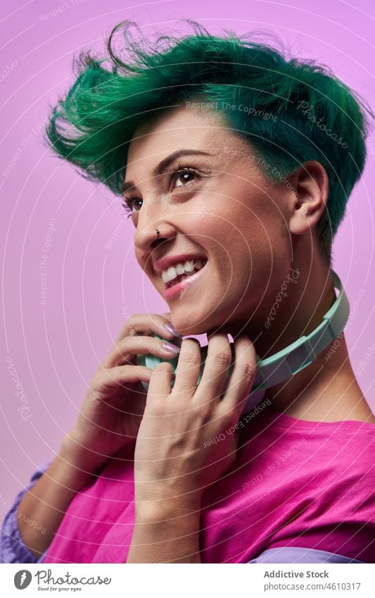 Charismatic woman with headphones in retro outfit meloman style millennial 80s fashion design music song listen audio studio green hair female model short hair