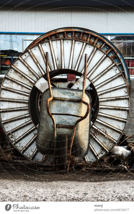 Construction site idyll. Wheelbarrows, Schaibtruchn, Garette, Radlbock, leaned against cable bobbin. Coil Technology Bobine cable drum Storage depot Round rusty