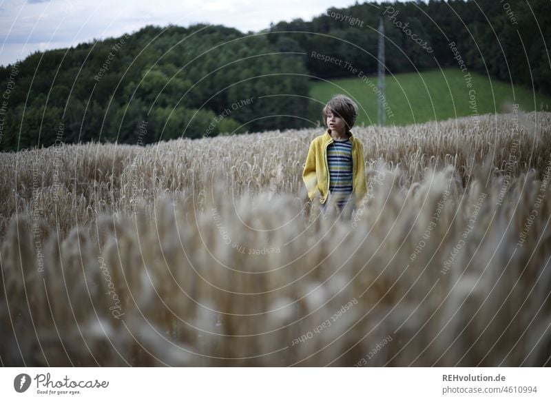 Child standing in a field Nature Infancy Environment naturally Human being Boy (child) Environmental protection Meadow Exterior shot Clouds Sky cloudy grey sky