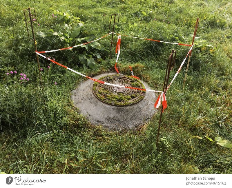 Barrier around gully on meadow Meadow slop Drainage system cordon barrier tape Red White Green Construction site peril Safety Reddish white Protection