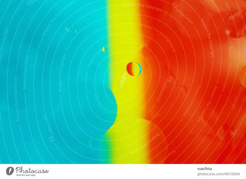 A beautiful and vibrant macro of oil bubbles on water with a yellow, blue and red stripe texture as background pattern with vintage filter abstract wallpaper