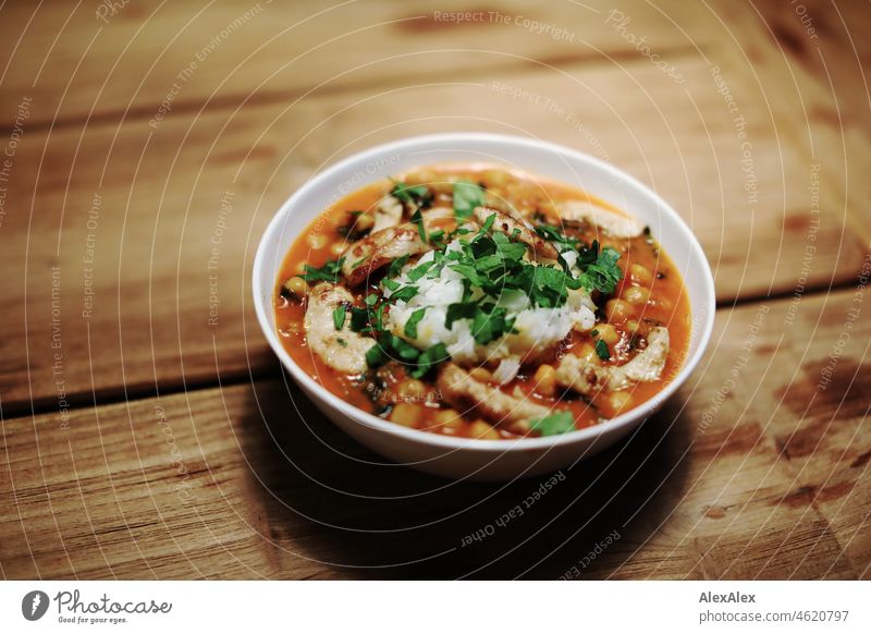 Delicious yellow lentil chicken curry with herbs in a white soup bowl on a wooden table Curry powder Chicken curry Parsley Yellow tart Lentils Giggle broom