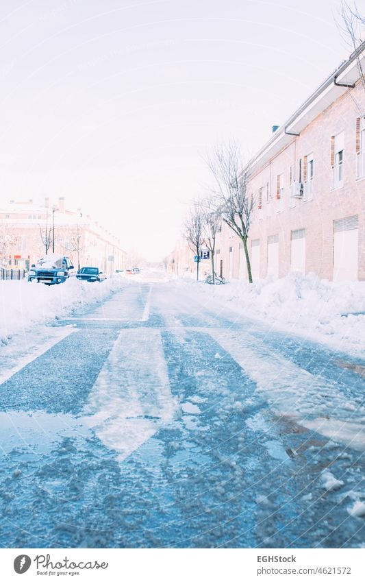 Street full of ice after a heavy snowfall with cars buried under the snow. Winter season. street winter weather blizzard road city cold outdoor storm