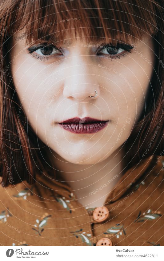 Close up portrait of a redhead woman looking straight to camera with confidence. Serious business concept, never hesitate, professional style. person pretty