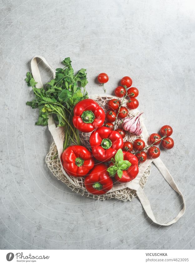 Eco-friendly shopping bag with various vegetables and herbs on gray background. Top view. Sustainable life style. No plastic. Zero waste concept. eco friendly