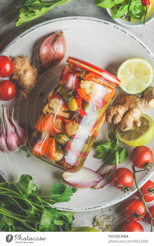 Close up of preserve jar with various pickled vegetables on plate with ingredients. Top view. close up top view tomato salad green healthy meal delicious food