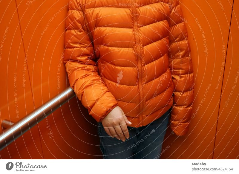 Down jacket in orange in an elevator in the old coal washing at the coal mine Zollverein in Essen in the Ruhr area down jacket Downy feather winter jacket