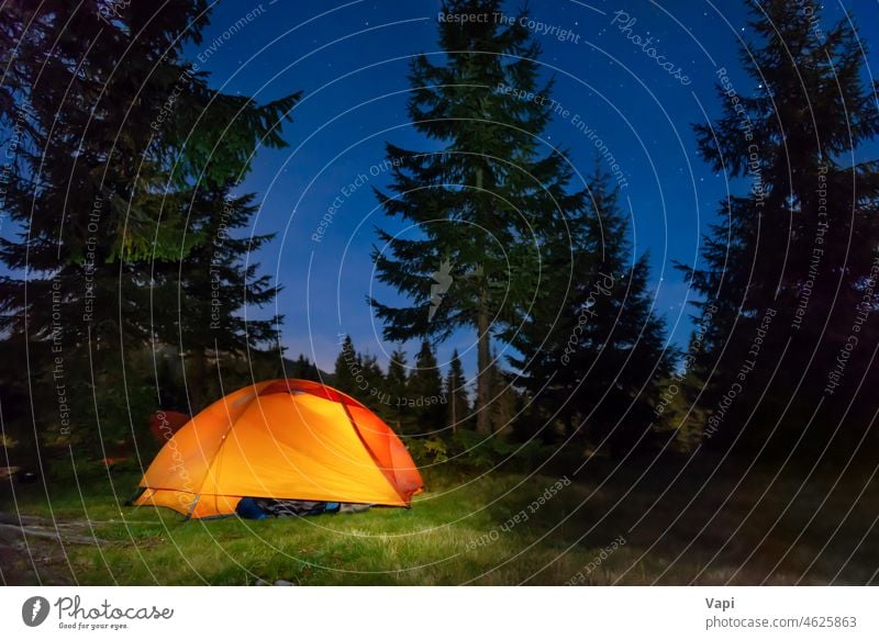 Illuminated tent in night forest mountains illuminated stars nature landscape red orange yellow outdoor light travel sky tree grass pine summer hiking camp