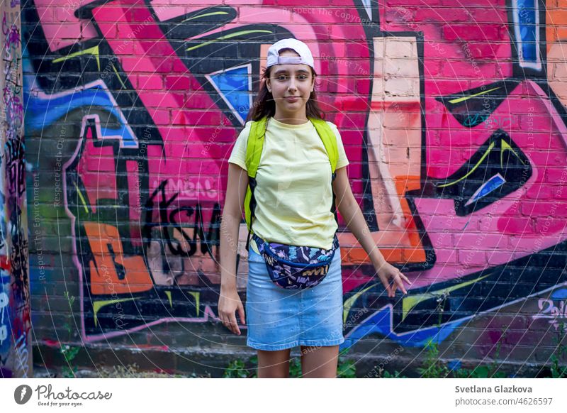 Teenager girl portrait on the street against the background of the wall with graffiti teenager street art street photography having fun gen z generation z city