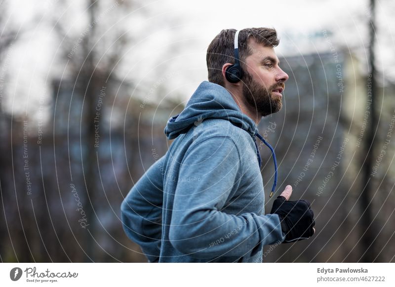 Young man running in the city people cold weather autumn sportsman strength motivation determination one person bodybuilding energy handsome confident guy