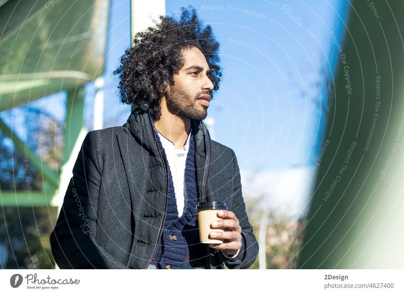 Handsome modern african american man with beard smiling positive standing at the street drinking a take away cup of coffee afro male holding fashionable