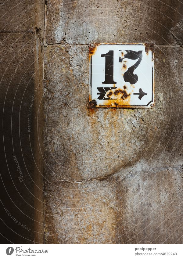 House number sign No.17 house number plate Digits and numbers Wall (building) Wall (barrier) Signs and labeling Facade Arrow Exterior shot Deserted