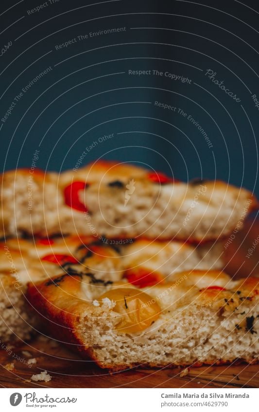 Homemade Italian Focaccia, with tomato and olive oil on a rustic wooden background. appetizer bake baked bakery black background bread cherry tomatoes closeup