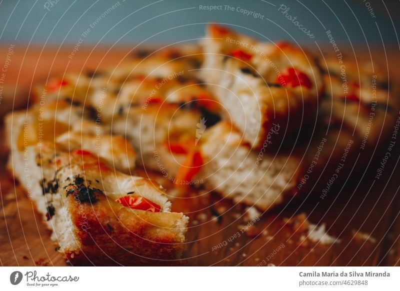 Homemade Italian Focaccia, with tomato and olive oil on a rustic wooden background. appetizer bake baked bakery black background bread cherry tomatoes closeup