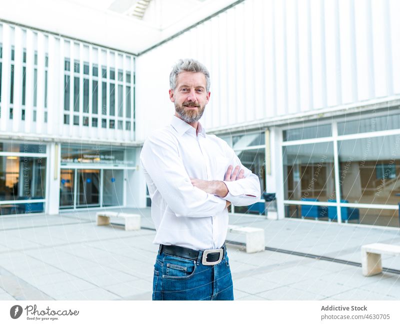 Positive man near modern building city street urban style decor design architecture male smile beard cheerful positive glad optimist content satisfied pleasant