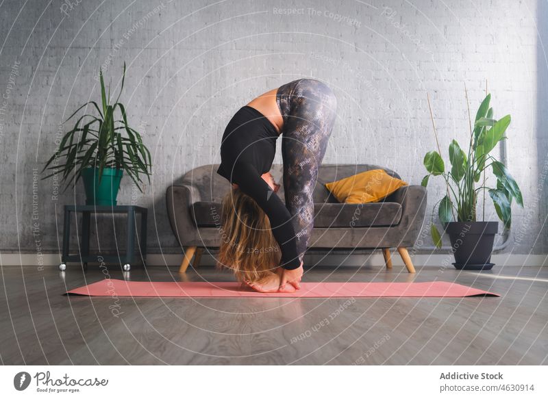 Woman bending forward in Padahastasana position woman meditate yoga padahastasana recovery stress relief mental practice spirit female mind mindfulness soul mat