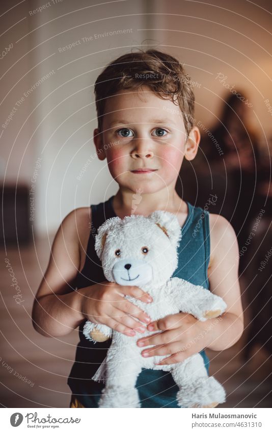 young child boy holding his teddy bear, looking at camera abandoned home adopted african health alone depressed black kid boy care child near childhood closeup