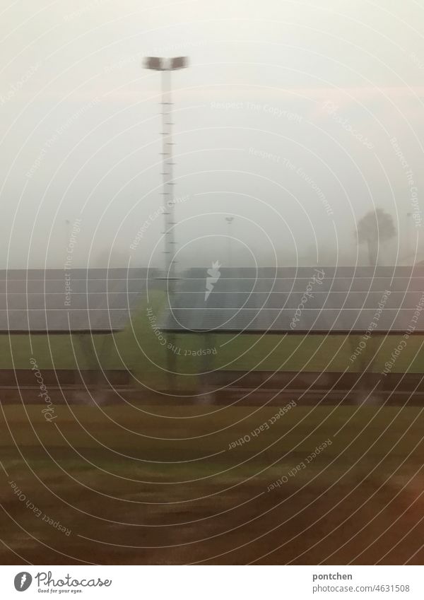 a soccer stadium with floodlight mast seen in the fog through the train window. Stadium Football stadium Floodlight futlichtmasten popular sport Football Club