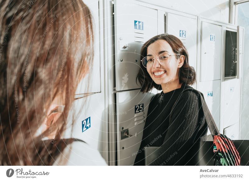 Couple of two young Female High School Students Talking By Lockers and saving and holding their material. Back to the university, study and learn concept. Exchange african students. Portrait