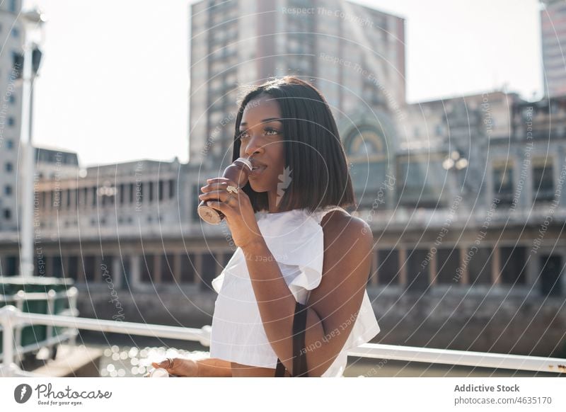 Black woman enjoying yogurt on street drink urban style chocolate summer female young black african american ethnic beverage trendy outfit daytime lifestyle