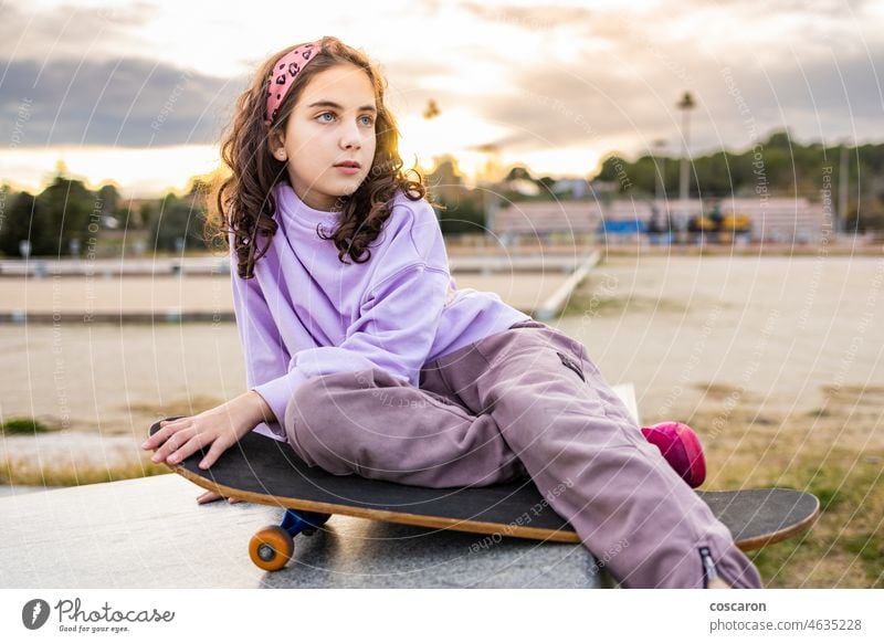 Little girl having fun with a skate board active activity beautiful caucasian child cool cute enjoy fashion female happy hipster hobby leisure lifestyle