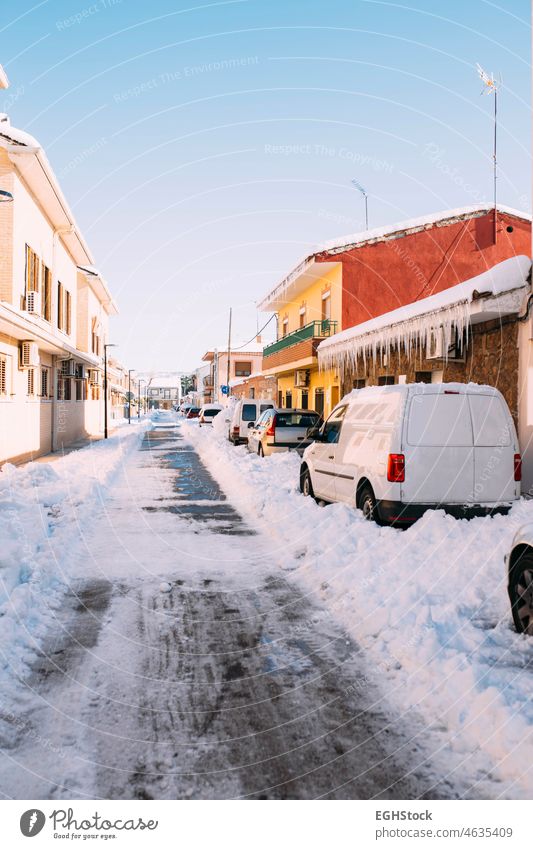 Street full of ice after a heavy snowfall with cars buried under the snow. Winter season. street winter weather blizzard road city cold outdoor storm