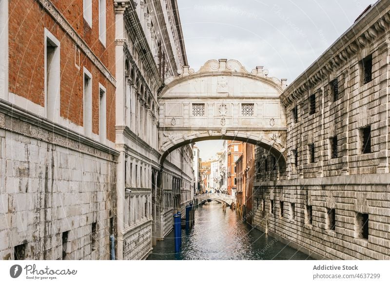 City channel between old buildings against cloudy sky canal city arch architecture historic heritage sightseeing travel tourism district scenic passage aged