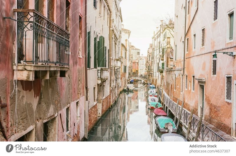 Boats on arrow channel between old colored buildings canal boat architecture cityscape historic district sightseeing residential exterior shabby aged venice