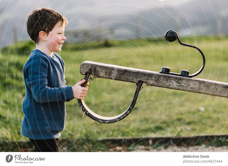 Boy playing with seesaw kid boy playground entertain childhood smile amusement street happy park playful summer pastime leisure recreation innocent lifestyle