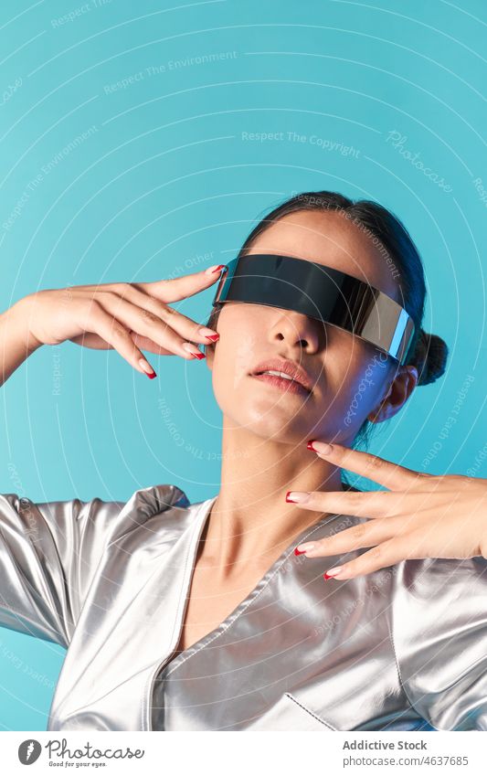 Ethnic woman touching face while experiencing virtual reality in futuristic glasses touch face style simulate augmented portrait trendy experience digital vr