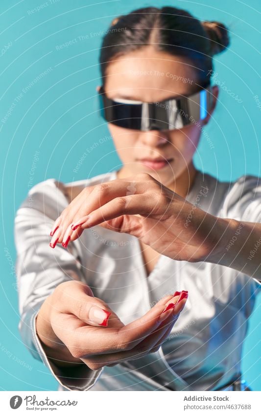 Young ethnic female touching invisible object while experiencing virtual reality in studio woman experience style cyberspace vr entertain digital augmented