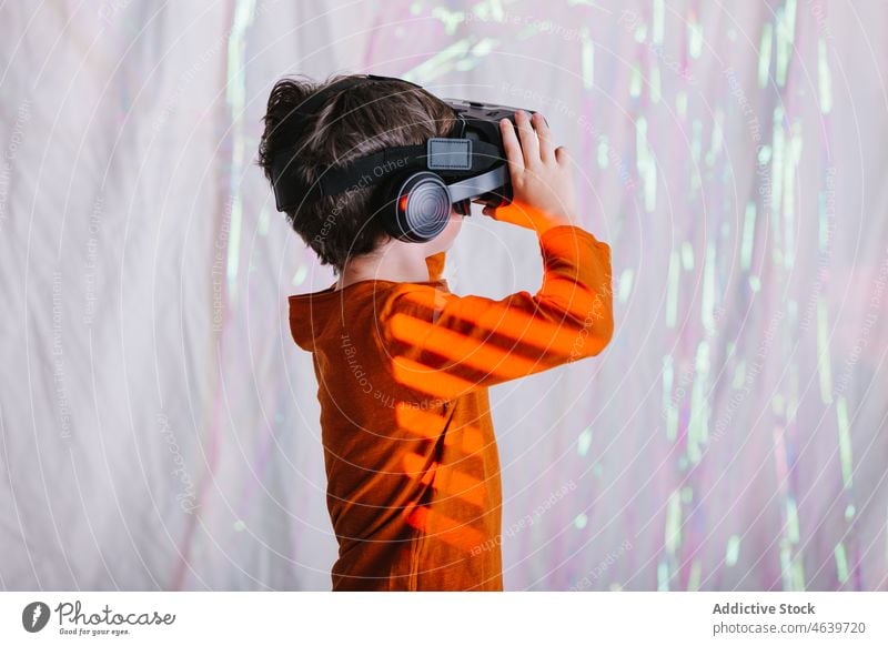 Boy exploring cyberspace in VR glasses child virtual reality explore boy experience vr goggles kid headset neon gadget device innovation digital futuristic