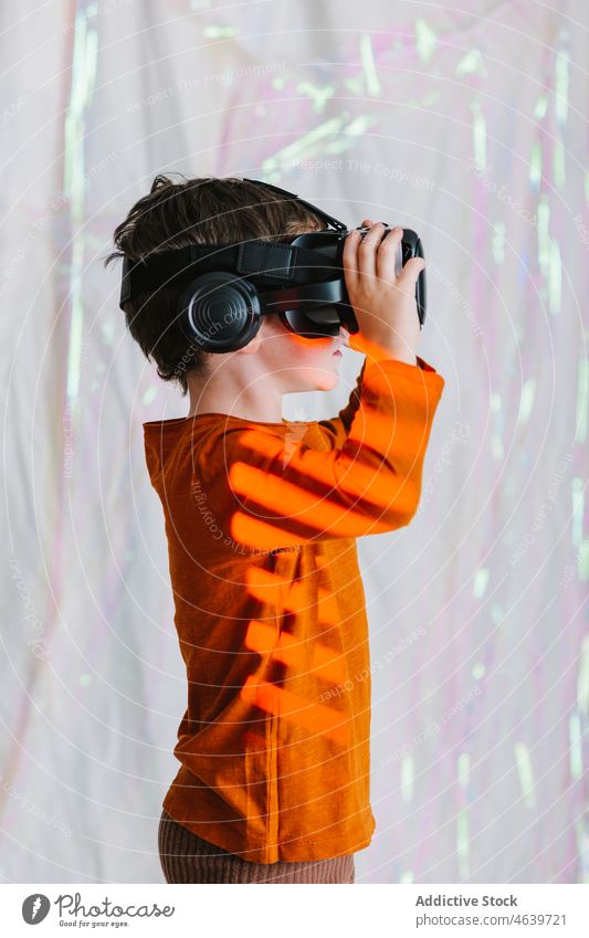 Boy exploring cyberspace in VR glasses child virtual reality explore boy experience vr goggles kid headset neon gadget device innovation digital futuristic