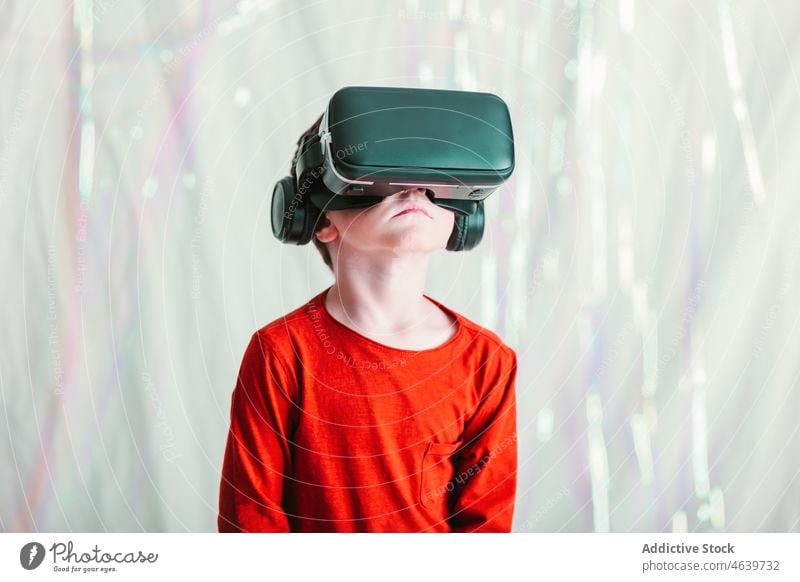 Boy exploring cyberspace in VR glasses child virtual reality explore boy experience vr goggles kid headset gadget device innovation digital futuristic simulate