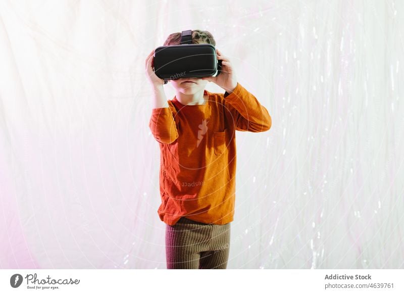 Boy exploring cyberspace in VR glasses child virtual reality explore boy experience vr goggles kid headset gadget device innovation digital futuristic simulate