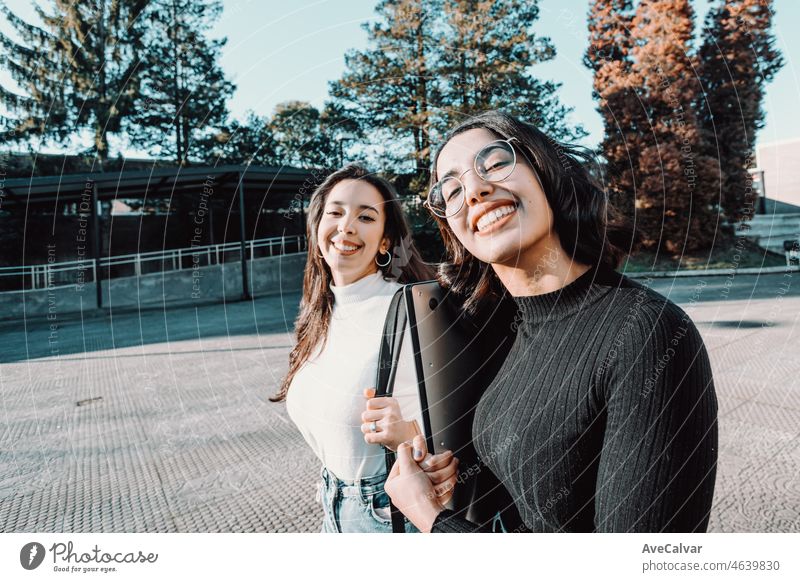 Two college students going for their class while talking and talking smiling to camera.Holding laptop backpack.Laugh, love friendship concept.New career, grade or study.African berber girls studying