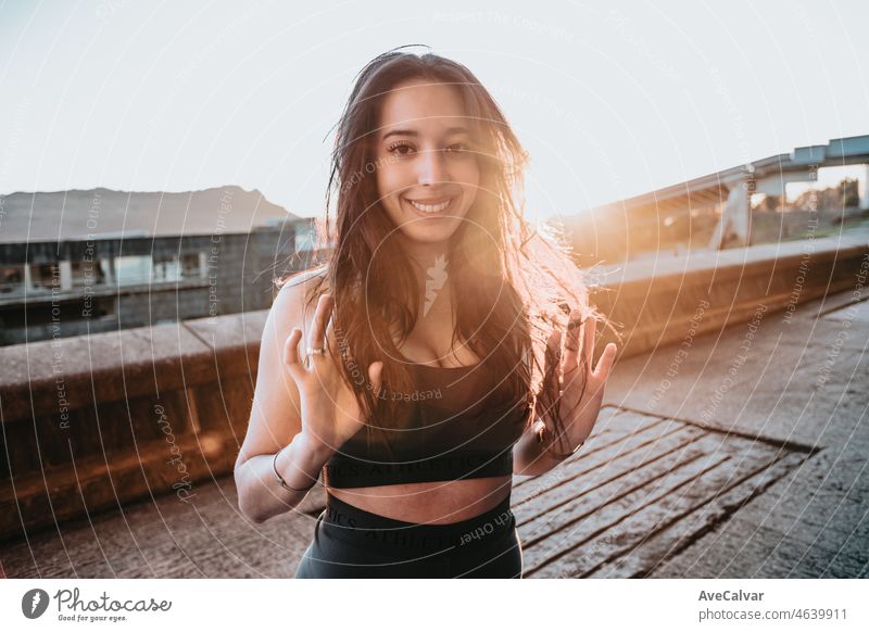 Portrait of young woman during the sunset after doing exercise during the sunset smile camera. African berber girl training healthy life urban concept. Commercial good vibes happiness portrait