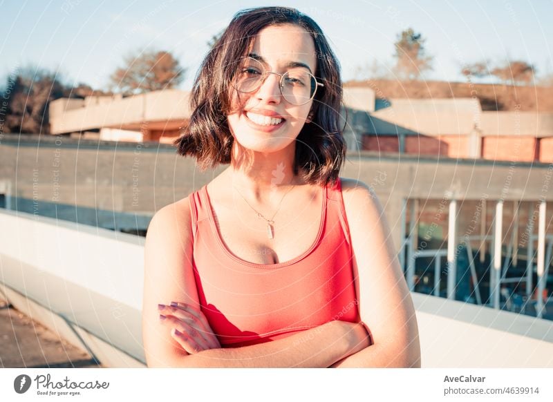 Portrait of a pretty young african berber fitness girl standing outdoors during a sunny day smiling to camera. Starting a healthy life, training every day, work hard, social network body